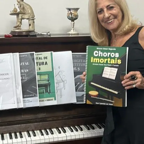 Cliente com o livro Choros Imortais sobre o piano