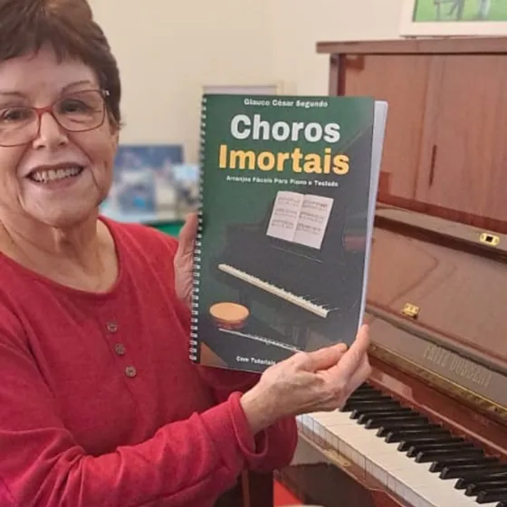 Cliente sorrindo com o livro Choros Imortais